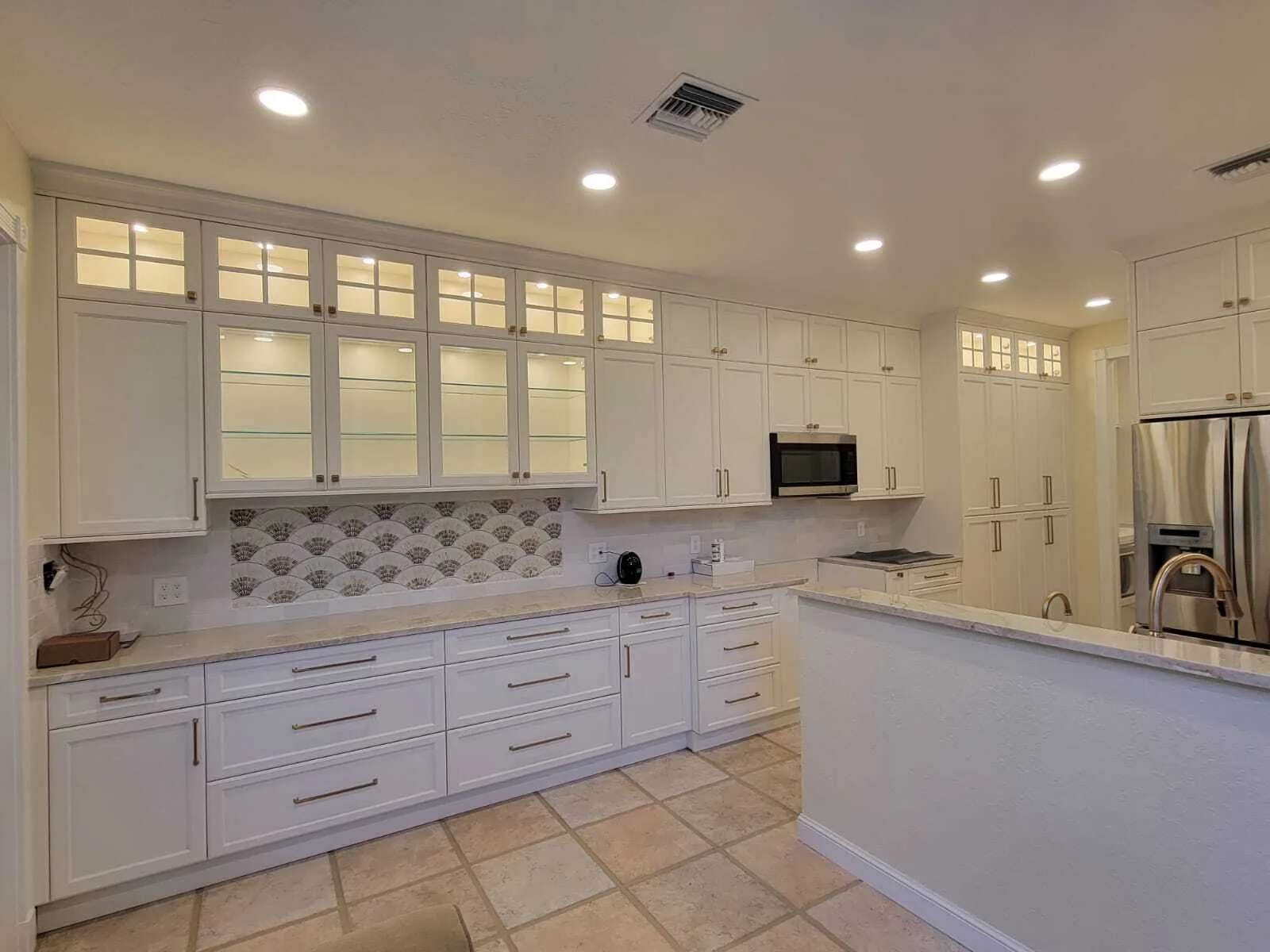 Freshly painted white kitchen cabinets with decorative tile backsplash